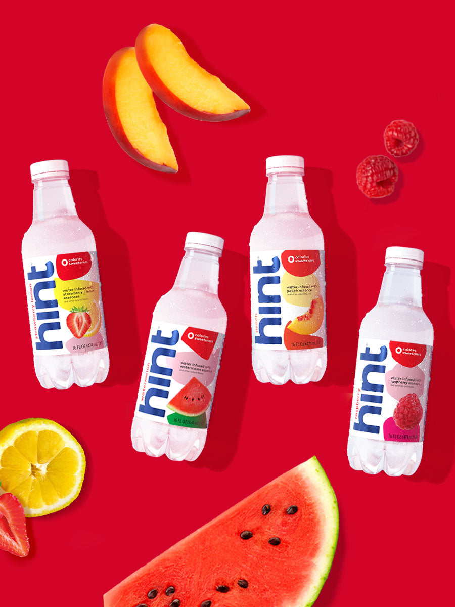 A collage of 4 hint water flavors laid on top of a red background with various fruits around them.