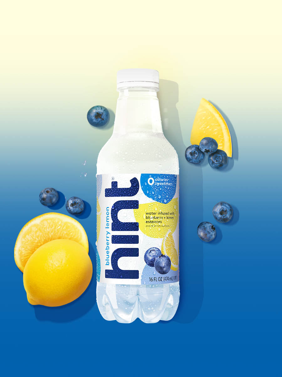 A bottle of Blueberry Lemon hint water on a blue yellow background. There are various fruit pieces in the background surrounding the bottle.