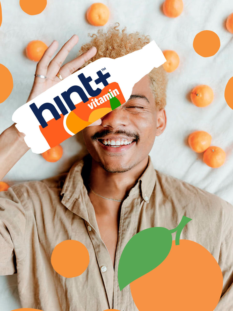 A model laying down holding a graphic of a clementine hint+ vitamin bottle. There are clementine graphics overlaying the image.