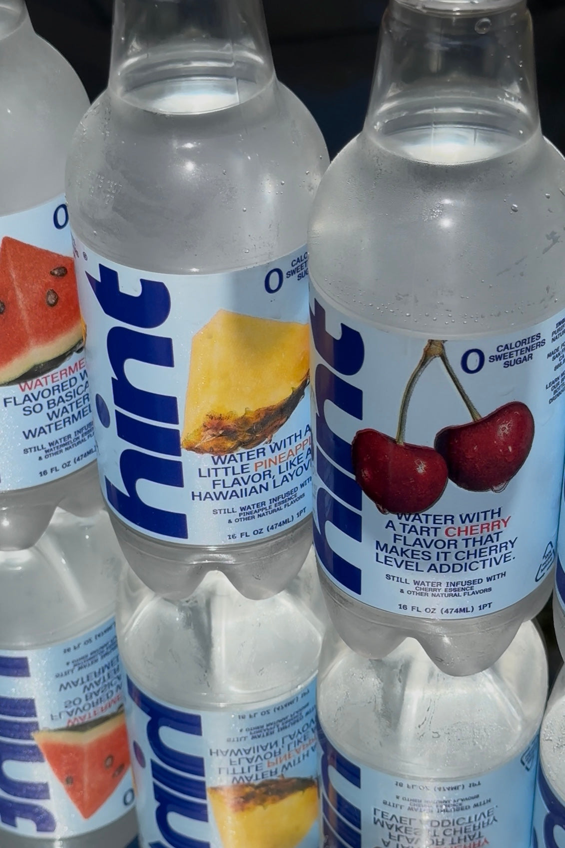 Bottles of Hint flavored water with pineapple, cherry, and watermelon illustrations on labels
